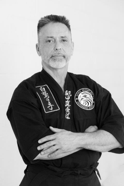Instructor John Gannon in black karate gi, showcasing martial arts expertise at Polander Academy of Martial Arts in Bethesda.