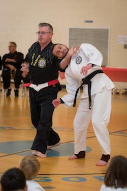 Martial arts demonstration at Polander Academy of Martial Arts in Bethesda, featuring instructor and student practicing self-defense techniques.