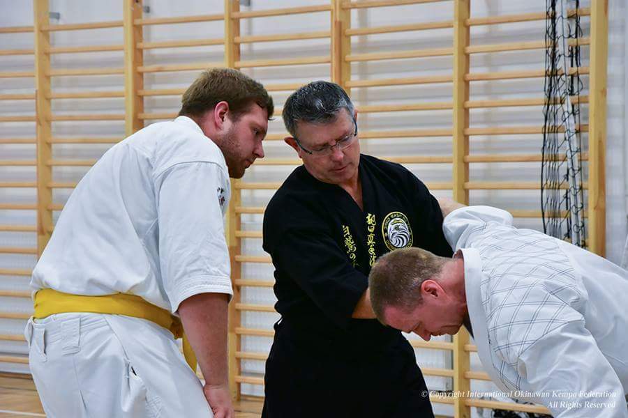 Two karate practitioners learning self-defense techniques under the guidance of an instructor at Polander Academy of Martial Arts in Bethesda, focusing on skill development and physical fitness.