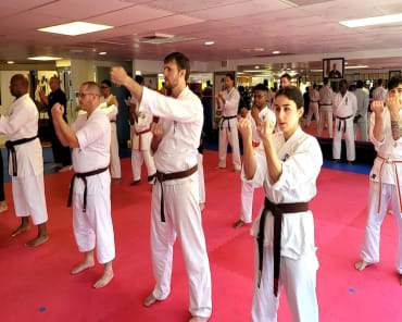 Group of martial arts students practicing karate techniques in a dojo at Polander Academy of Martial Arts in Bethesda, Maryland.